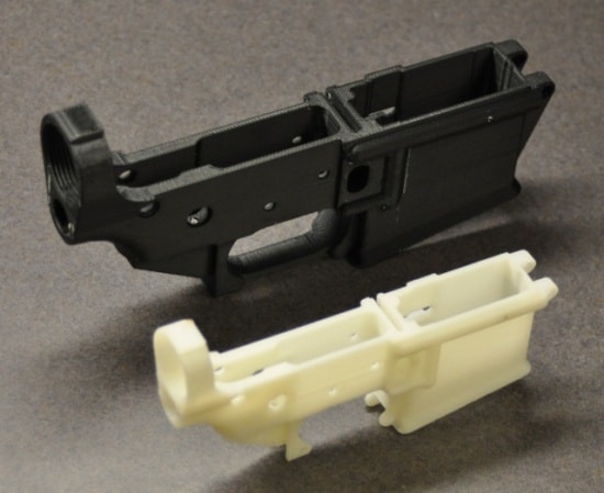 Black and white 3D printed plastic component with cylindrical opening and rectangular cutouts.