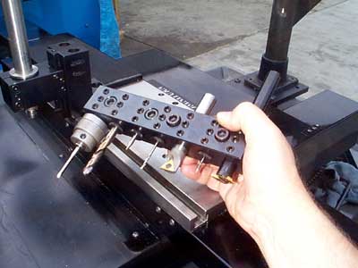 Black metal piece with holes and cylindrical attachment.