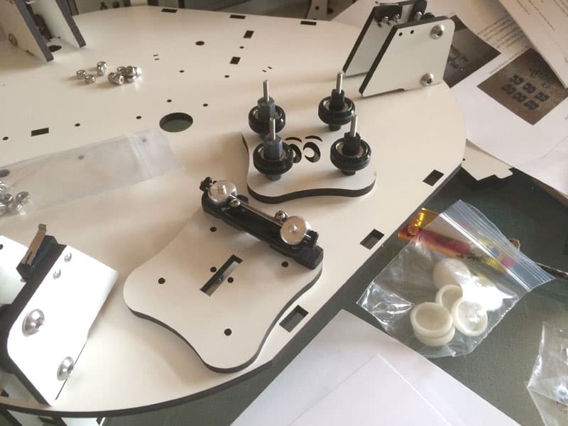 White metal object on workbench with scattered parts and tools.