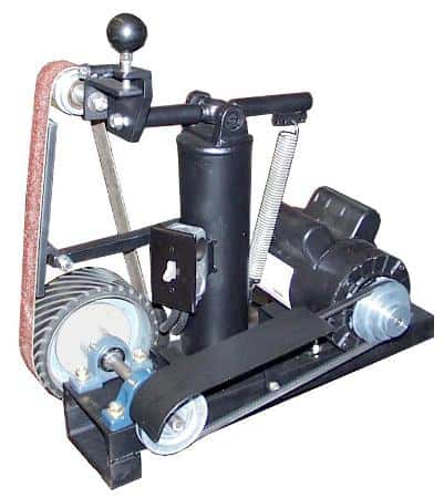 Black belt grinder with red sandpaper-covered belt on cylindrical base.