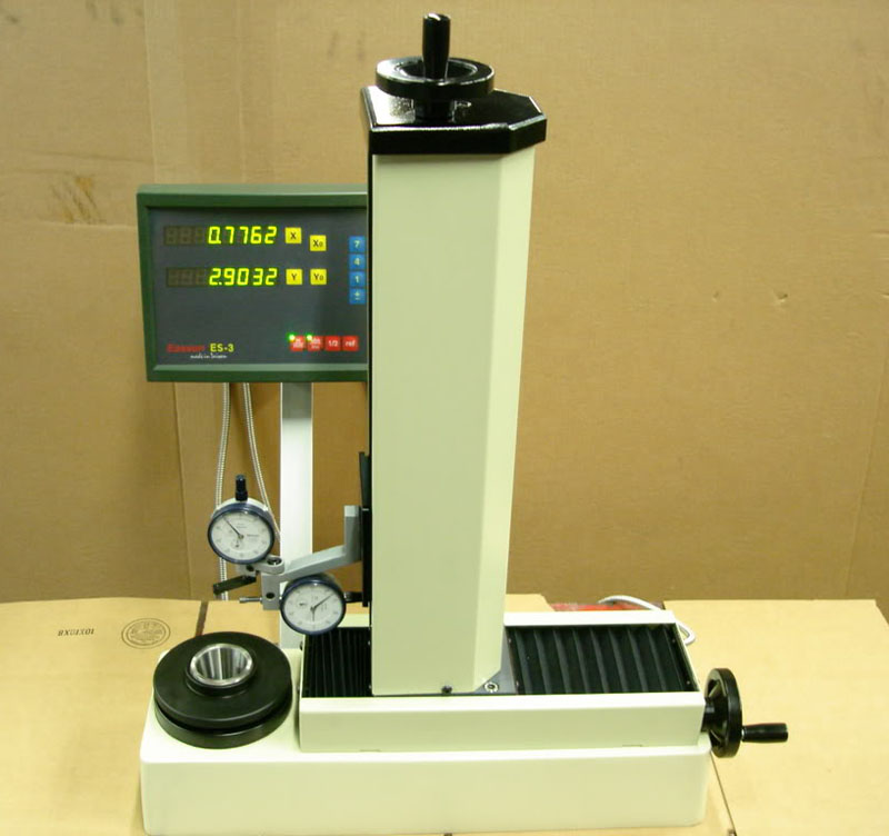 Digital display showing "0.7762", "X", "Y", "Z" coordinates on white device with gray background.