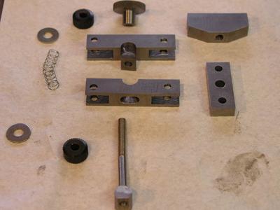 Metal components: flat pieces, round pieces with central holes, and assorted metal parts.