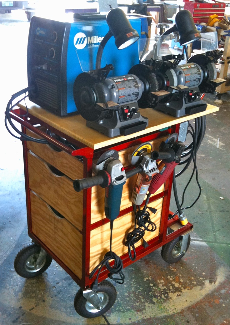 Collection of grinders on a wooden cart in a workshop setting.