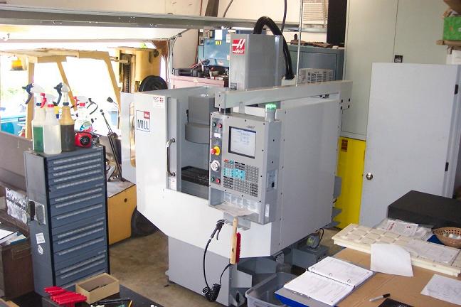 Industrial machinery in a workshop or factory setting, with metalworking equipment nearby.