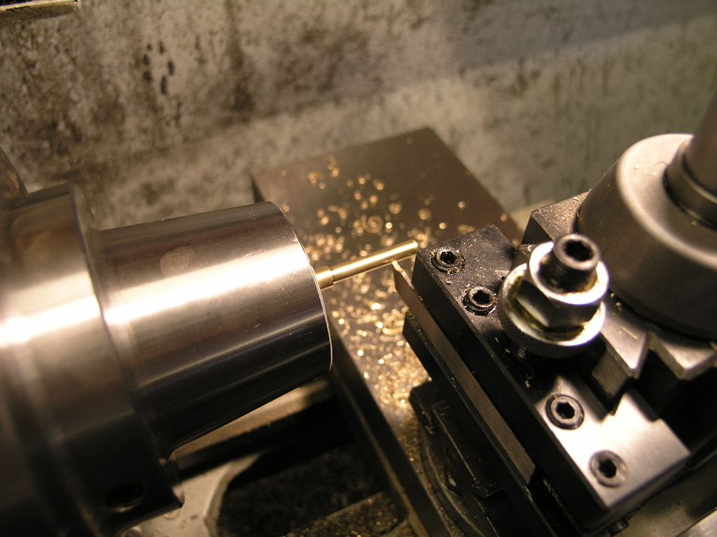 Lathe in operation with cutting tool and metal work.