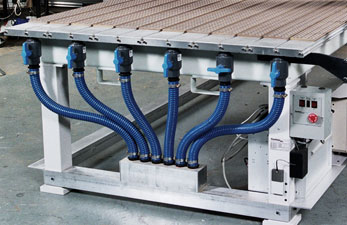 Large metal table with blue vacuum hoses and grid-patterned surface.