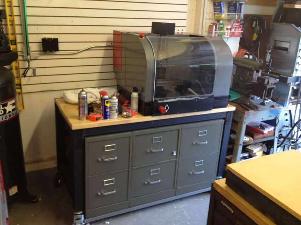 Well-equipped workshop with various tools, equipment, and a large metal cabinet with drawers and vice.