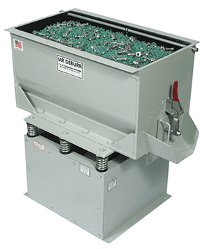 Industrial bin labeled MR DEBURR containing small metal parts in shades of green and silver.