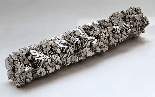 Silver-colored crystal with jagged edges and metallic sheen on white background.