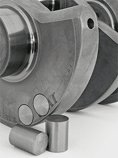 Metal part with two circular holes on a smooth surface, possibly aluminum.