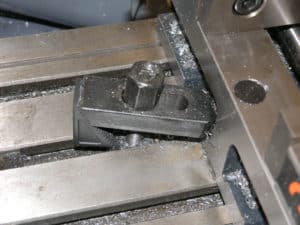 Metallic object with dark surface and small hole or indentation.