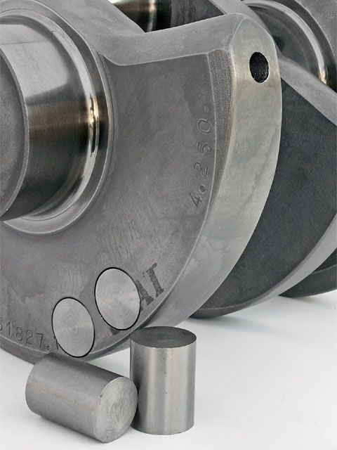 Metallic cylindrical object with two circular holes and a smooth metal surface.