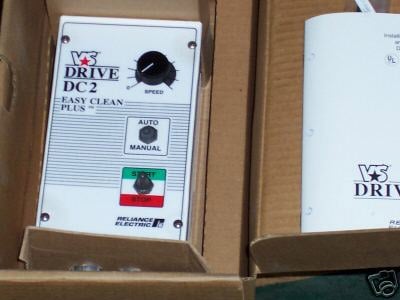 Electronic device with white panel, knobs, buttons, and "Drive DC2" label on a cardboard box background.