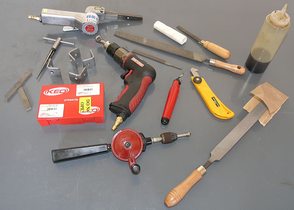 Grey surface with drill press, milling machine, and other metalworking equipment.