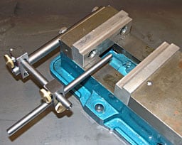 Large metal vise with blue base and silver jaws.