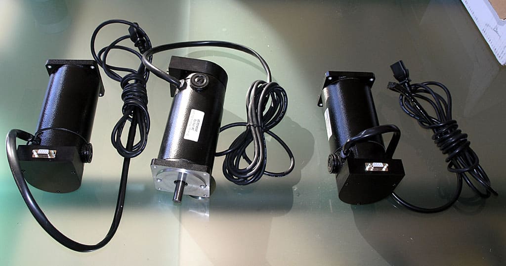Black electric motor with cord, cylindrical body, and metal plate.