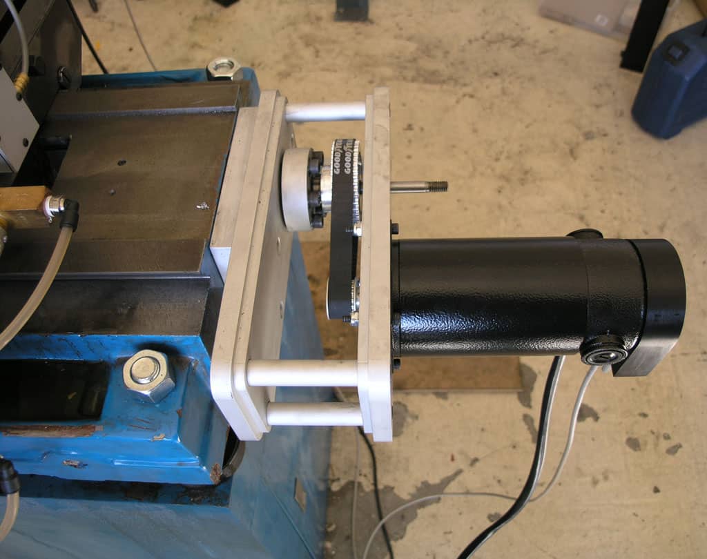 Metal machine with cylindrical component on concrete floor.