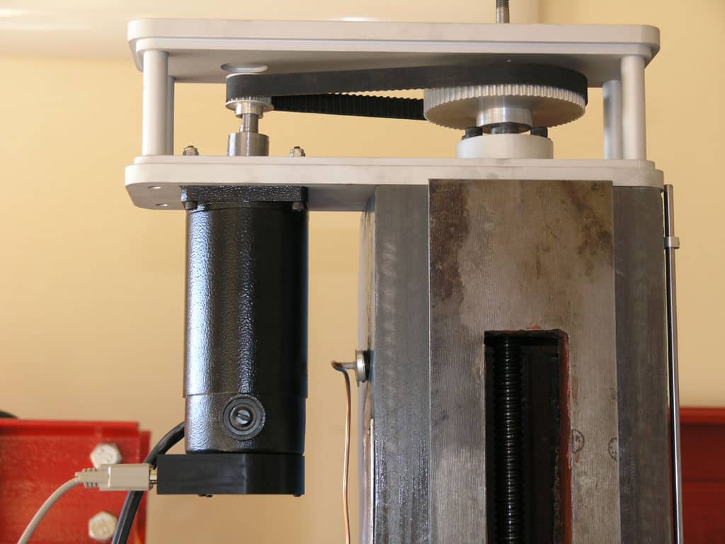 Mechanical device with gears and levers on a neutral background.