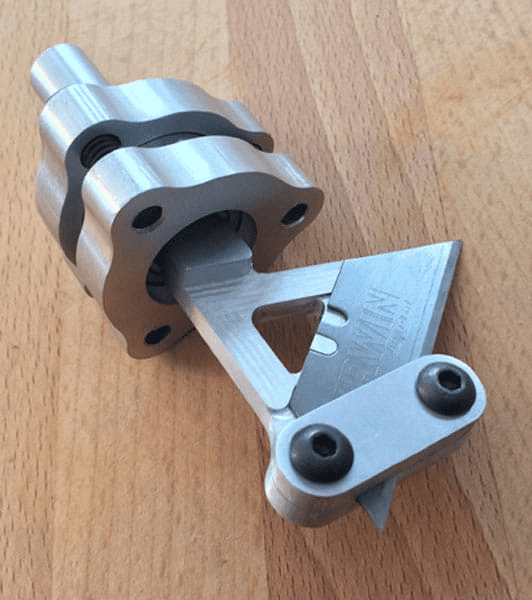 Silver metal part with triangular shape, two black bolts, and "MAGNATRACK USA" logo.